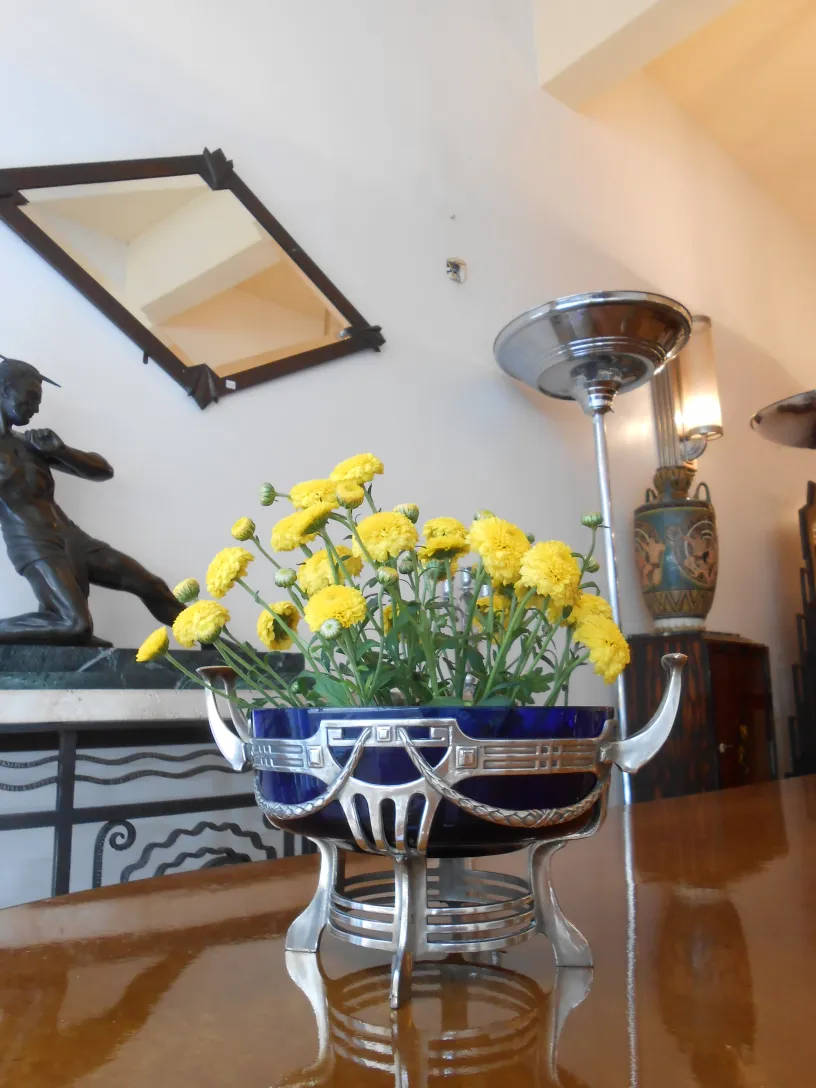 centro de mesa wmF antigo com flores amarelas em um ambiente elegante