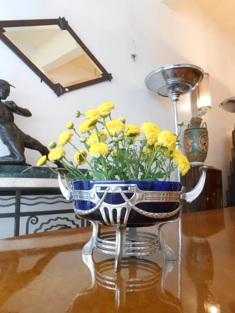 centro de mesa antigo WMF com flores amarelas em um ambiente elegante