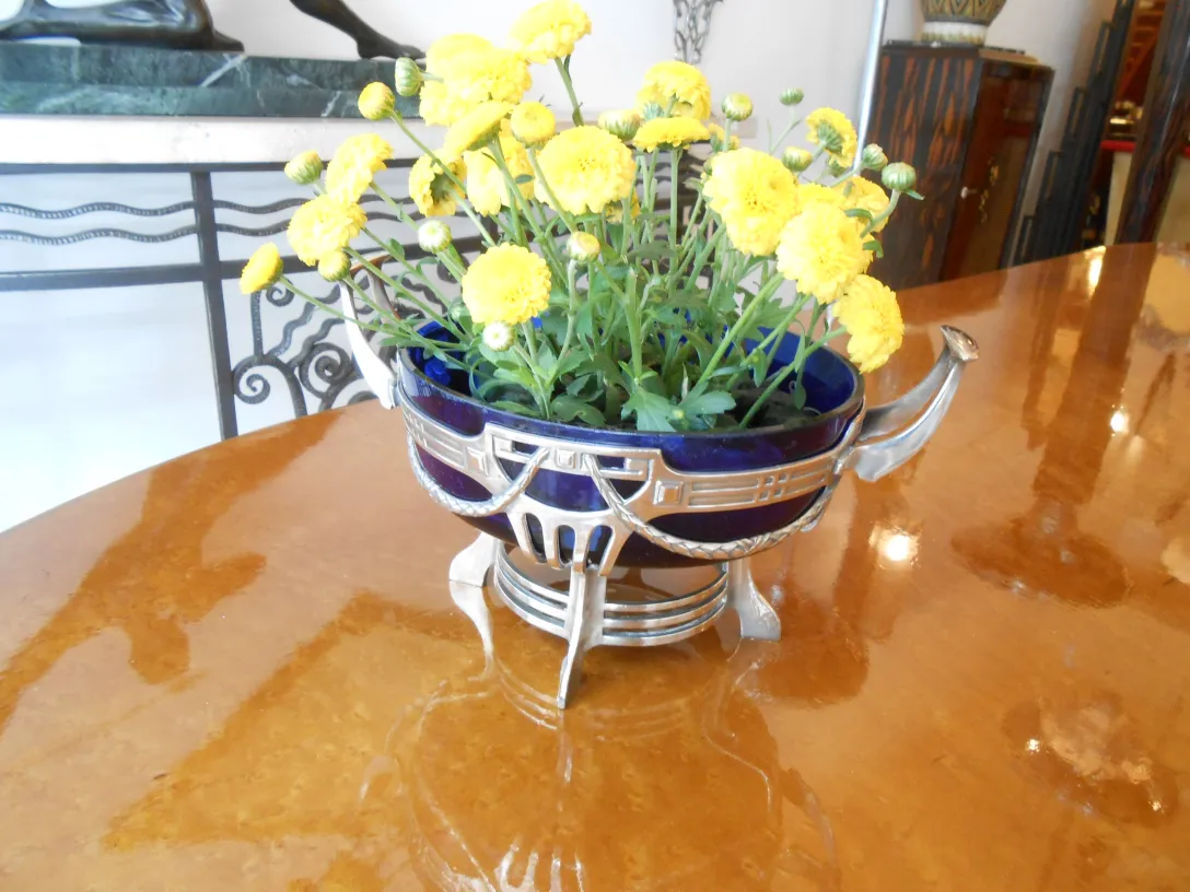 Centro de mesa WMF com flores amarelas em uma mesa brilhante, antiguidade decorativa.