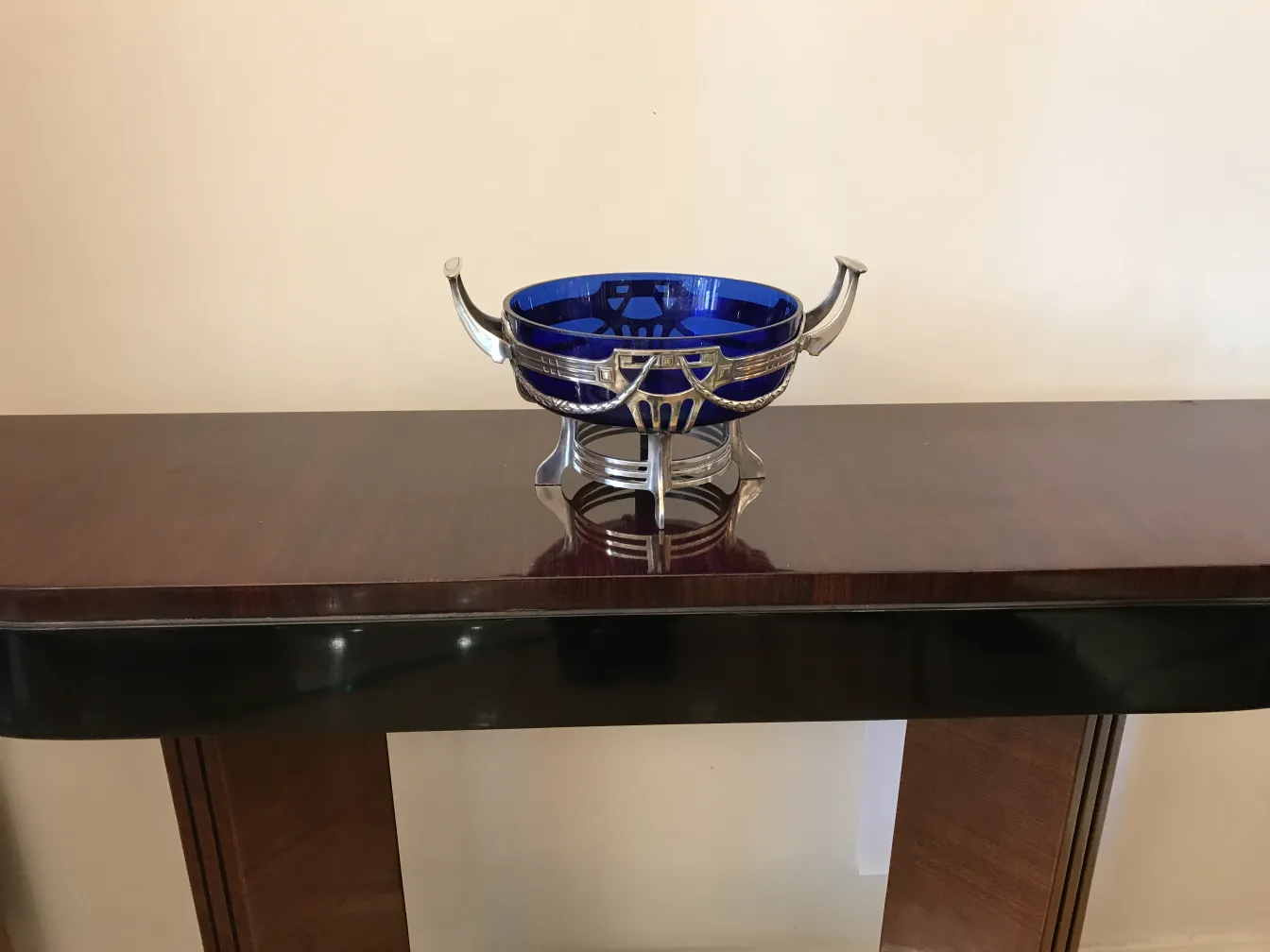 WMF centerpiece featuring a shiny blue bowl on a wooden table, set in a neutral environment.