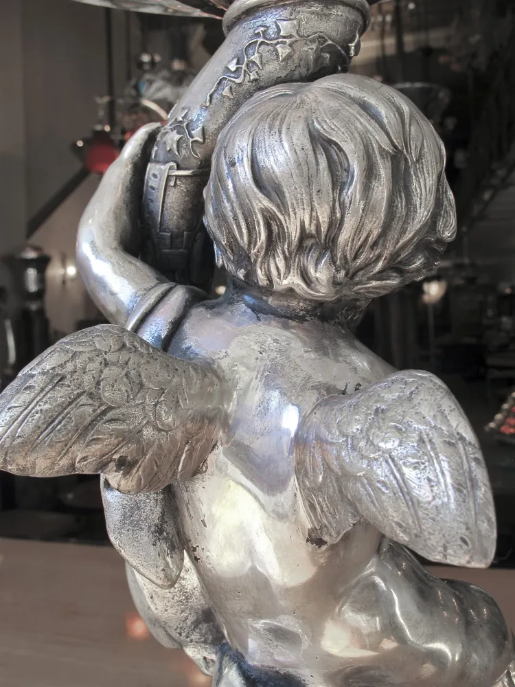 Antique WMF centerpiece with decorative cherub figure. Elegant setting.