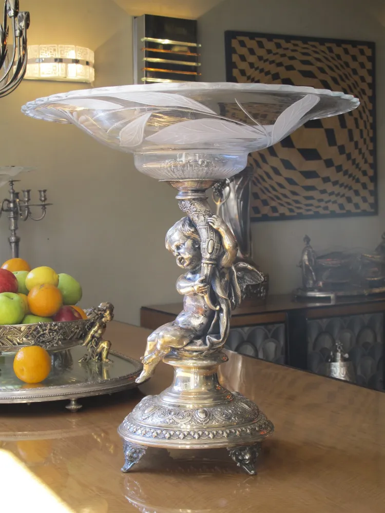 Centro de mesa antigo WMF com figura de criança, ambiente elegante