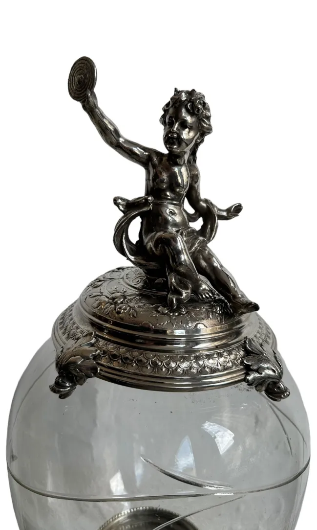 antique centerpiece with ornate decorations and a figurine on top, elegant setting