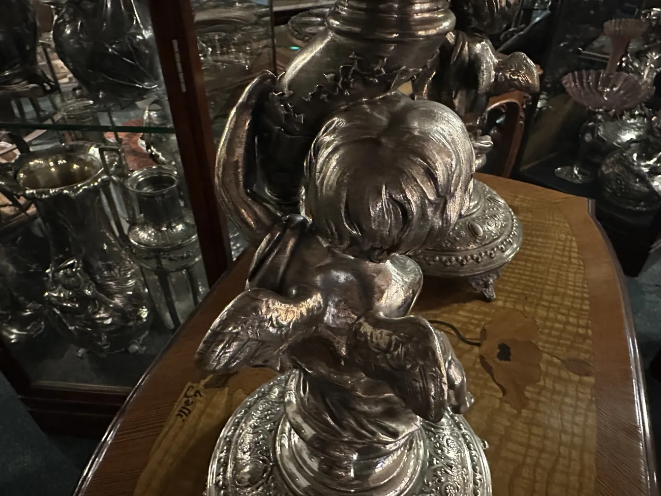 centre de table wmf ancien avec des détails décoratifs et des anges dans le design, entouré d'autres objets vintage