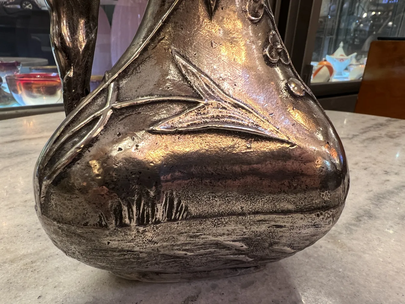 pichet ancien avec un motif floral en relief et des détails