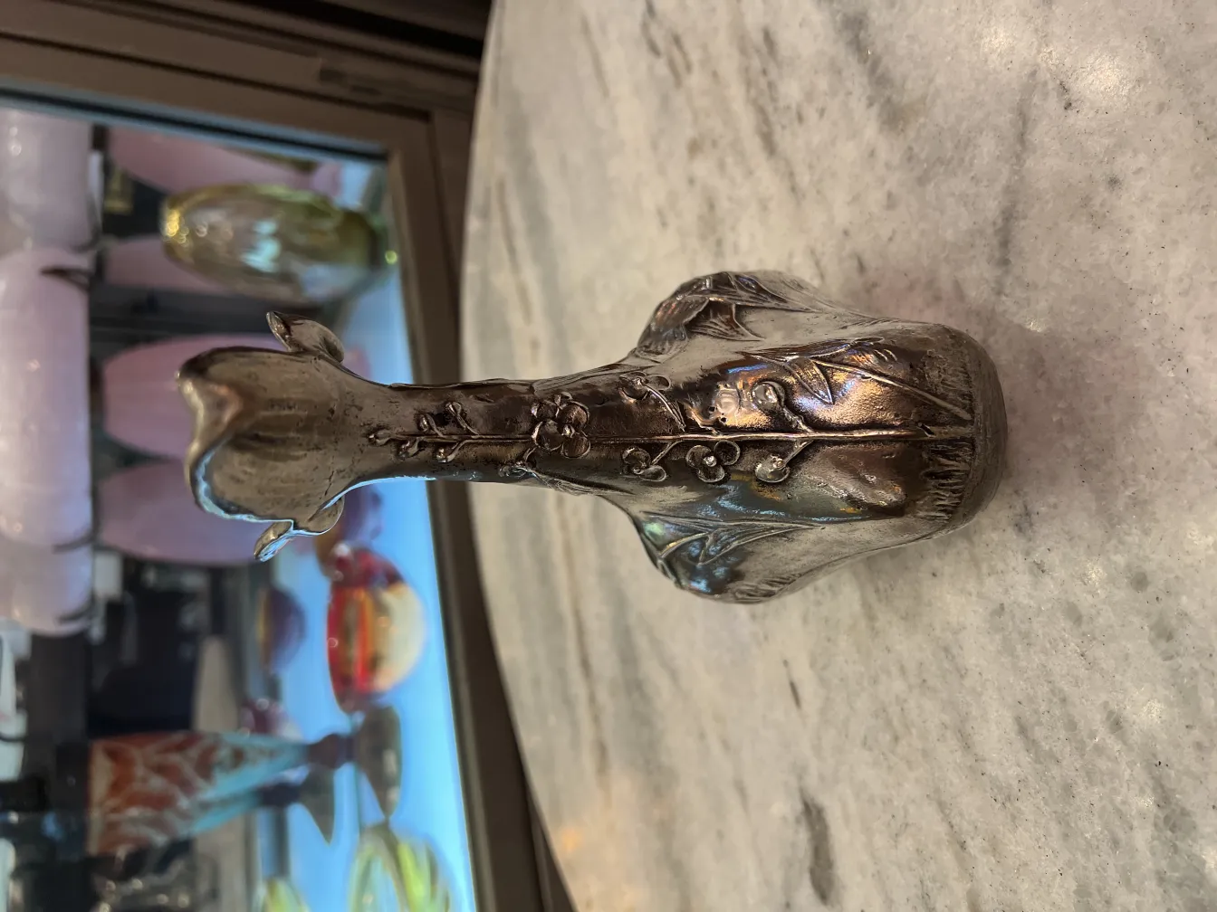 vue de face d'un pichet ancien avec décoration florale, objets colorés en arrière-plan