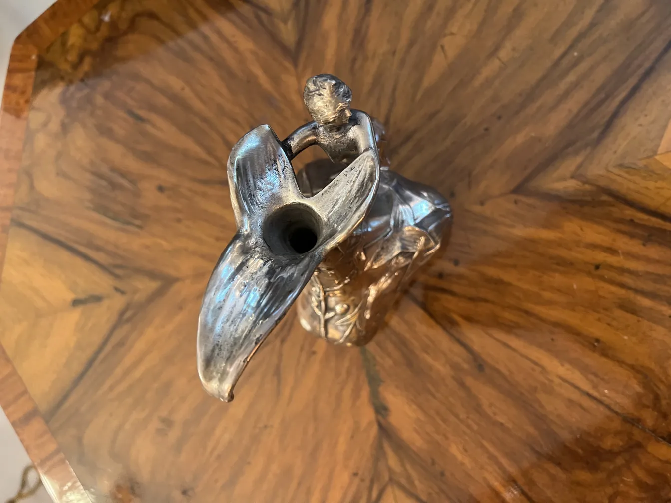 Antiga jarra com figura ornamental na parte superior, ambiente acolhedor.