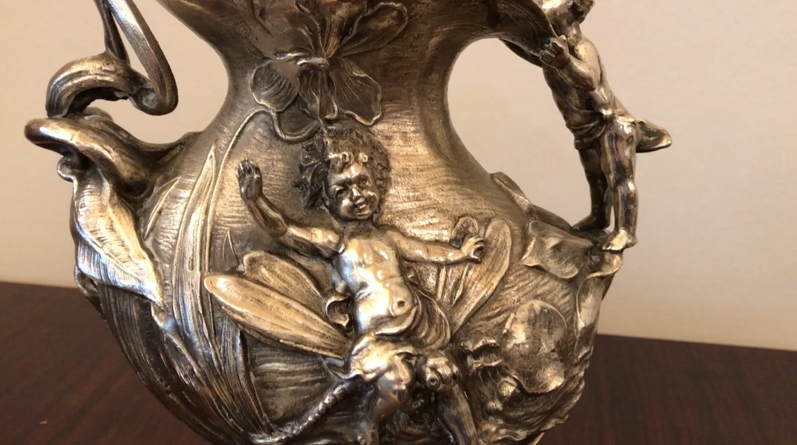 Pichet ancien décoratif avec figures et fleurs, ambiance élégante