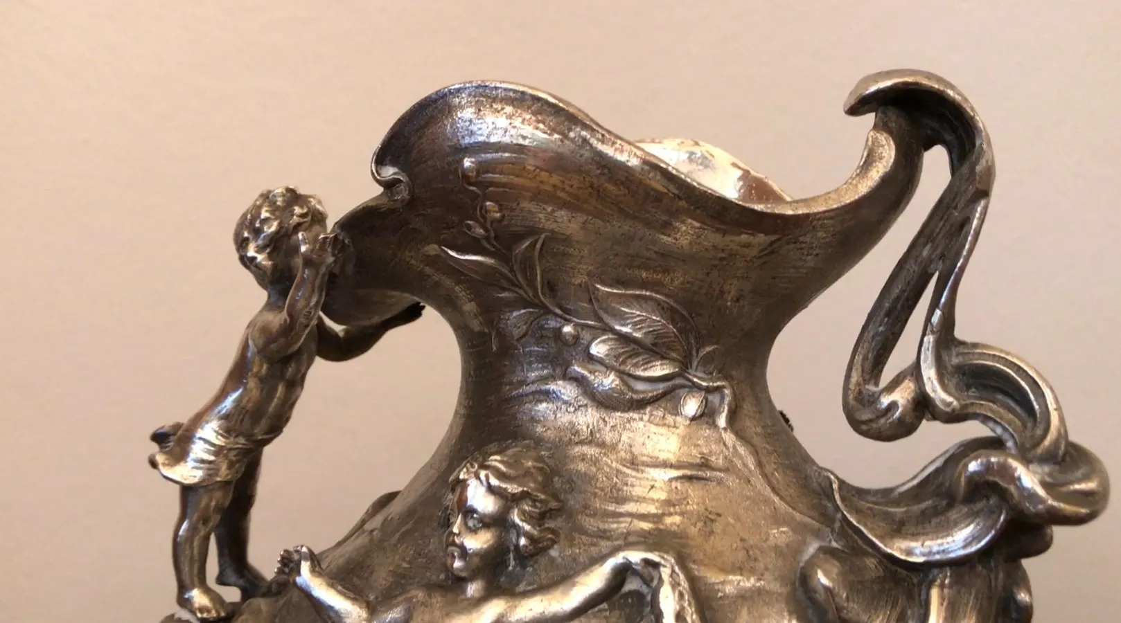 brocca antica con figure scolpite e forma elegante