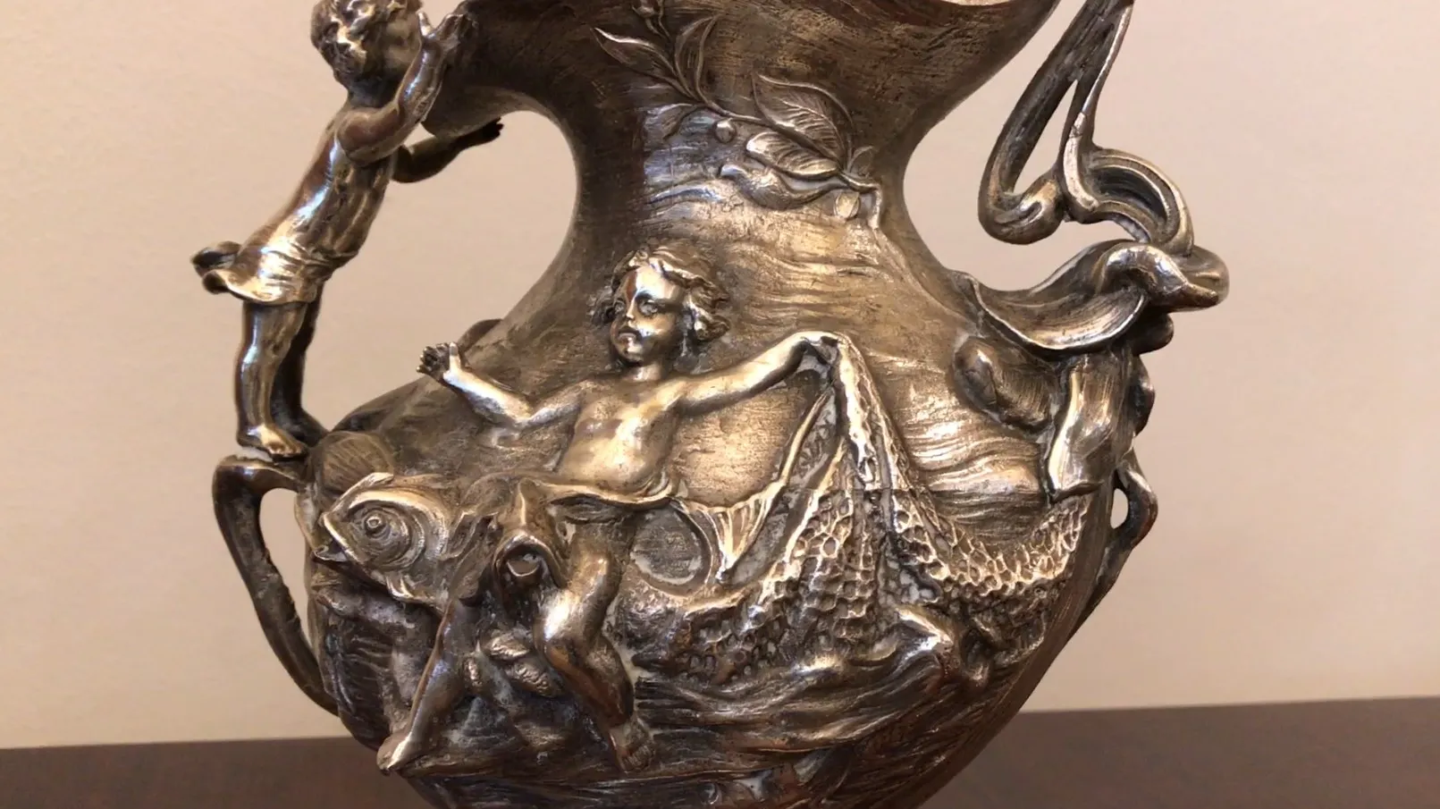 pichet ancien avec des chérubins en relief mettant en valeur sa beauté