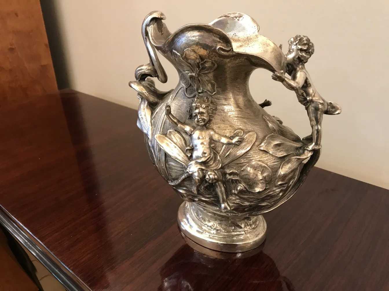 antiker krug dekoriert mit figuren von kindern und blumen, in einem klassischen umfeld