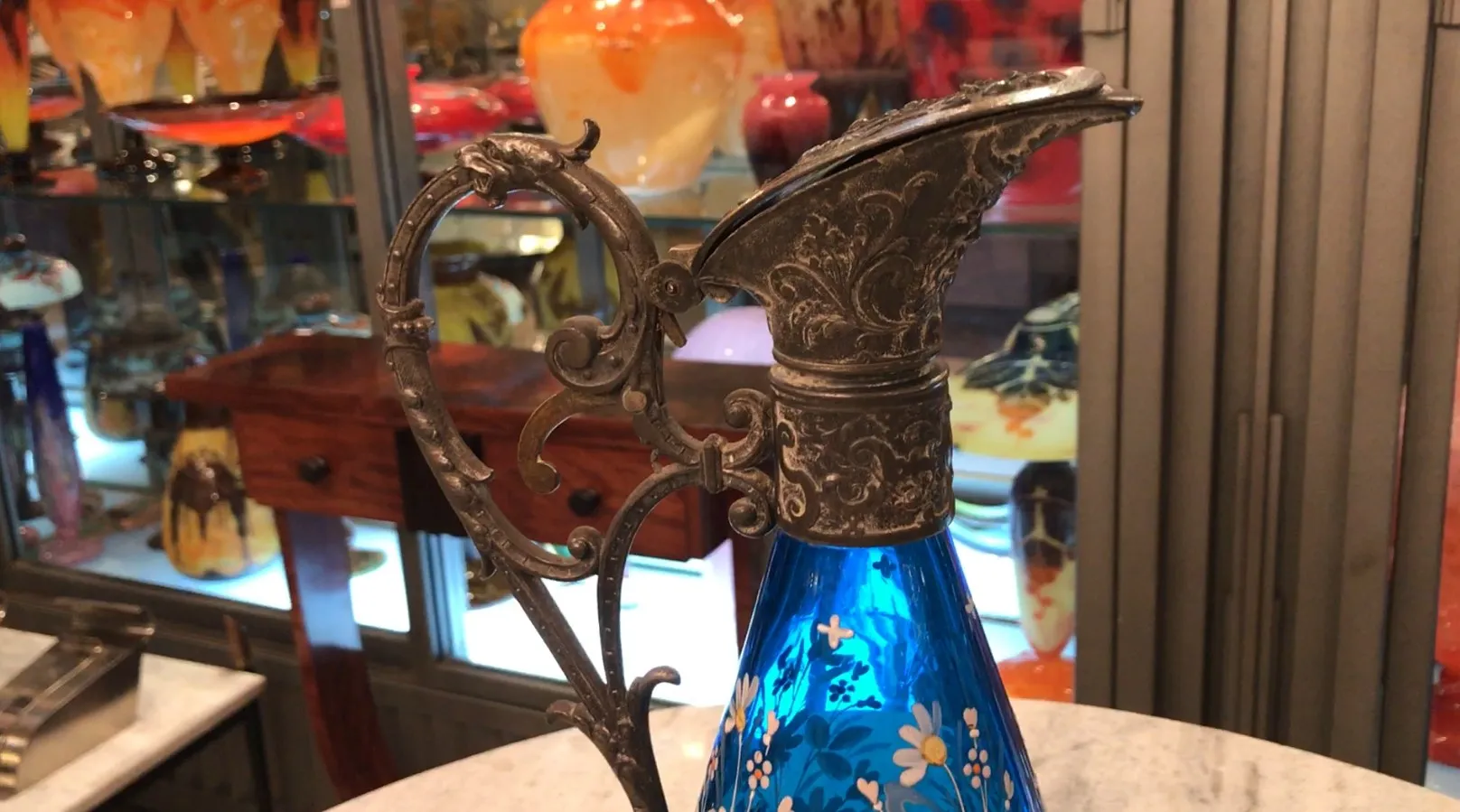 Antiga jarra wmfs azul com flor decorativa em um ambiente elegante.