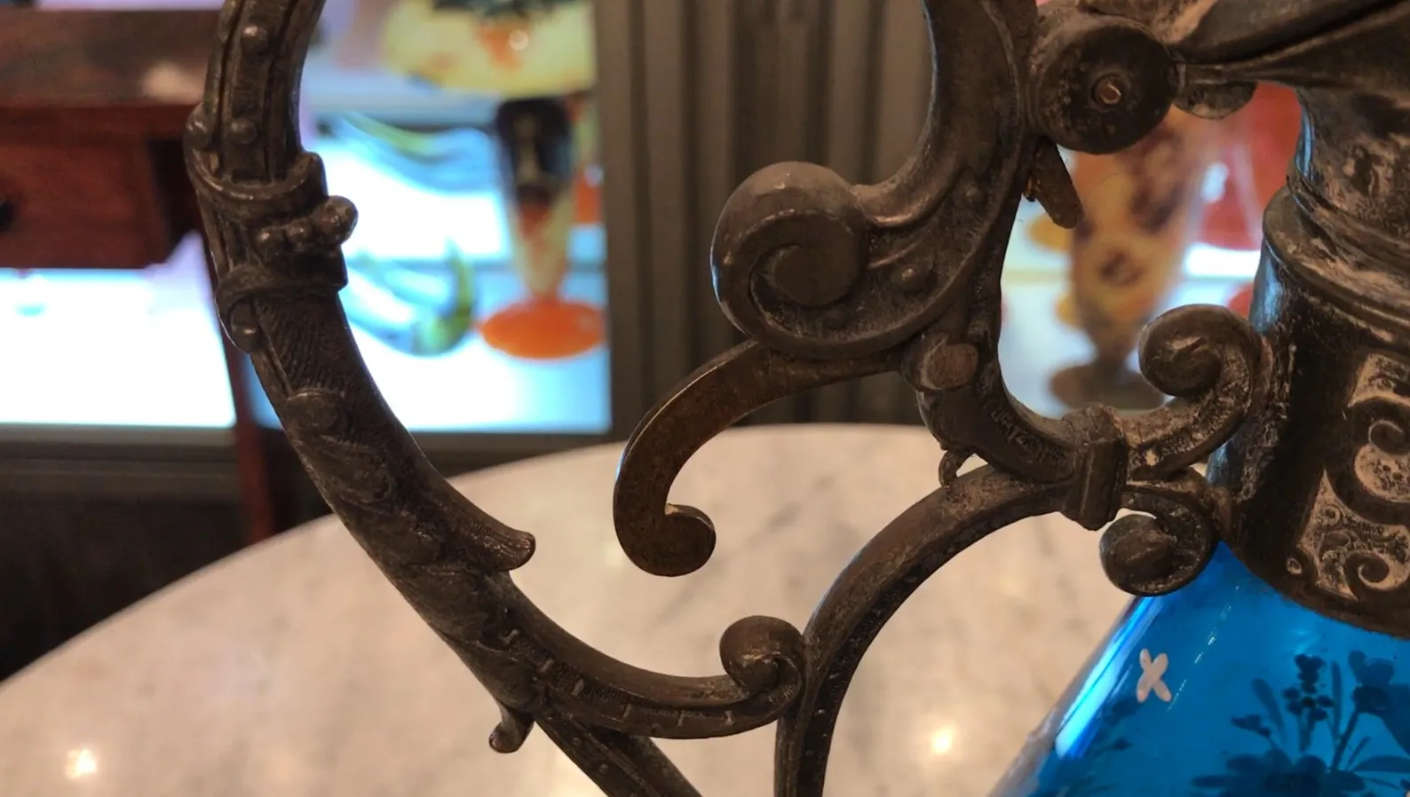 gros plan de deux pichets antiques WMF avec des détails ornementaux en arrière-plan d'autres objets anciens