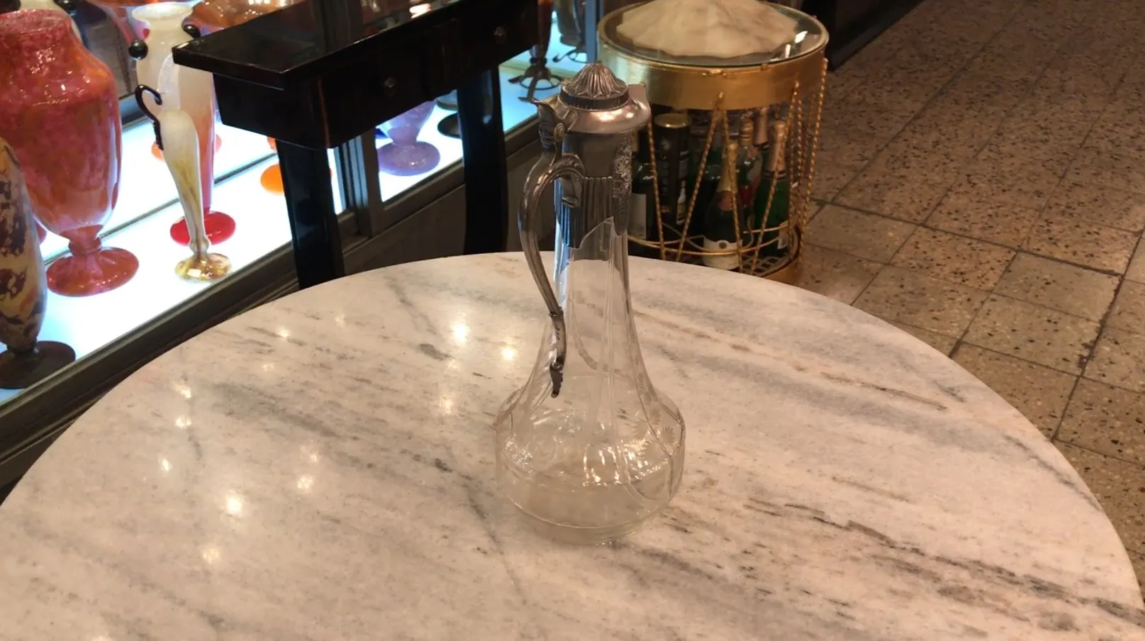 Antigua jarra WMF con diseño elegante sobre mesa de mármol