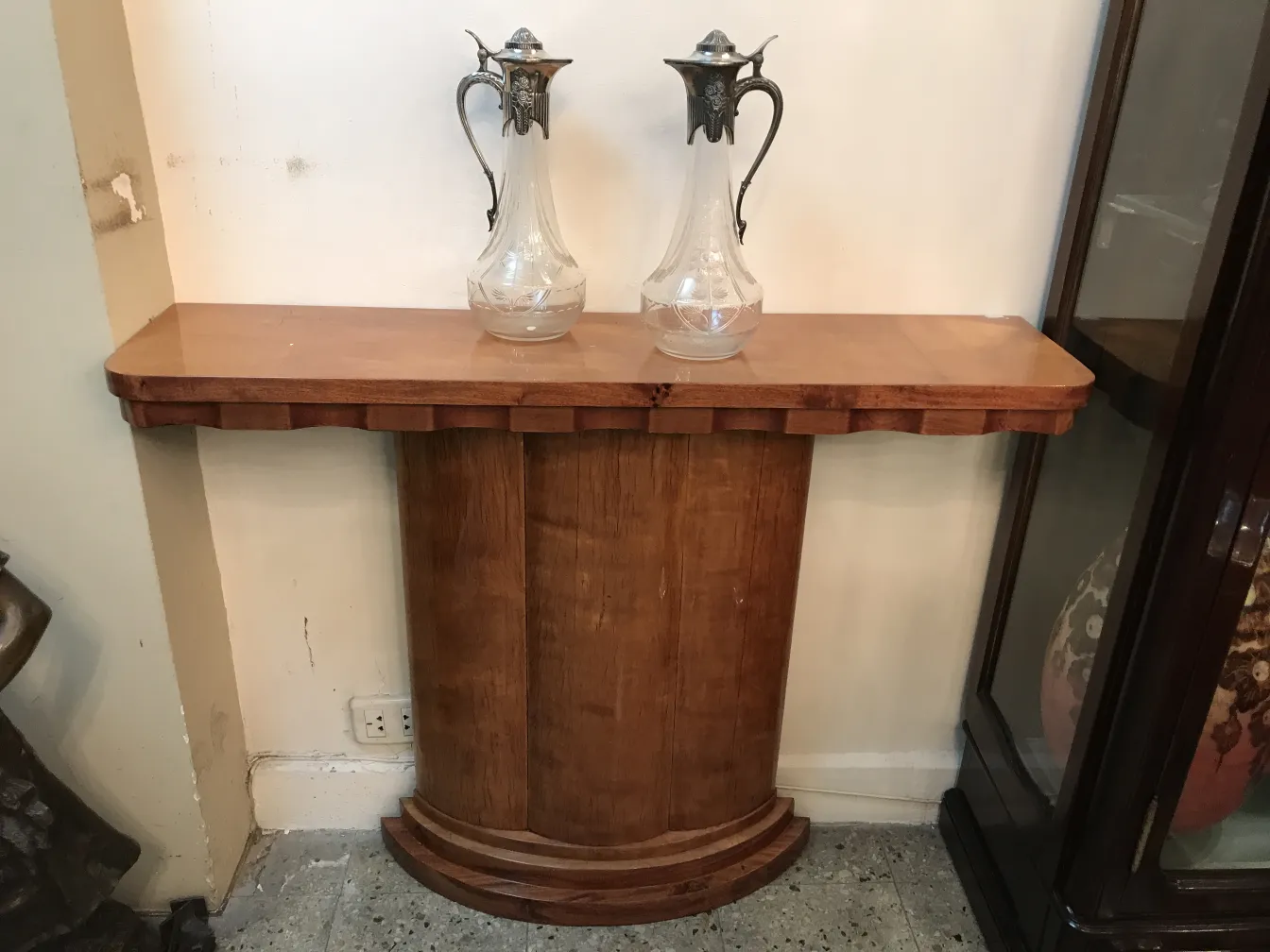 Deux pichets élégants sur une table ancienne, fond neutre.