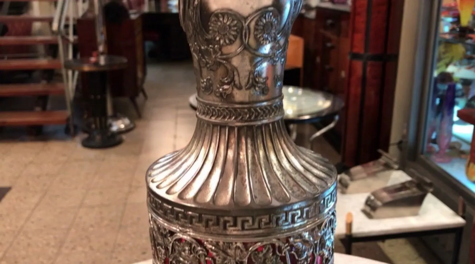 duas jarras antigas WMF com design intricado e detalhes decorativos, em um ambiente aconchegante.
