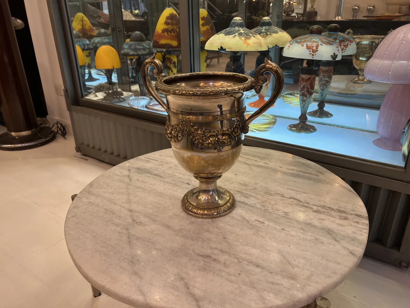 Antique champagne cooler wmfs on marble table, with floral decoration.