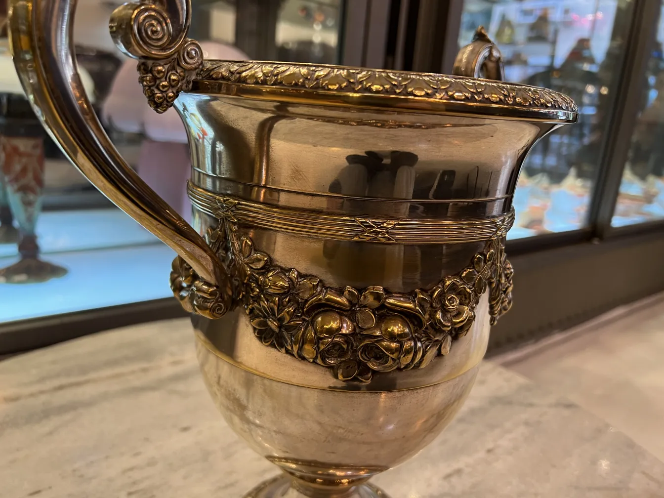 여기 꽃 장식이 있는 고대 샴페인 쿨러 WMF의 모습이 있습니다.