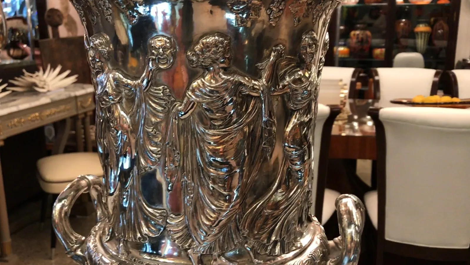 2 raffreddatori per champagne, adornati con figure classiche in un ambiente elegante.