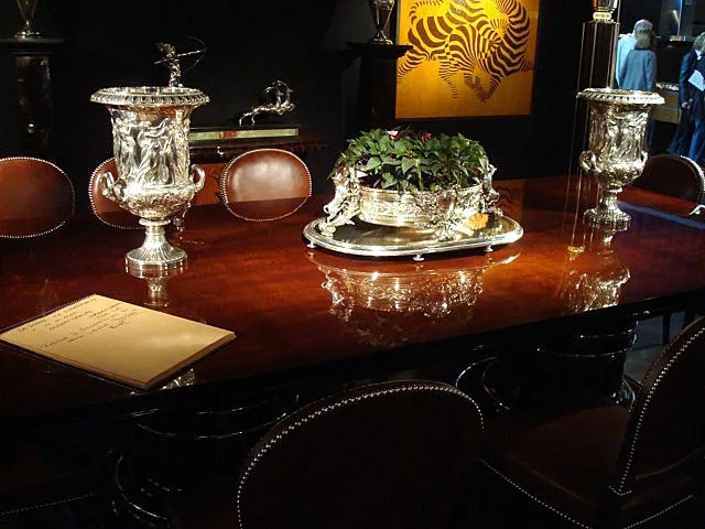 2 seaux à champagne anciens avec détails décoratifs, à côté d'une table en bois