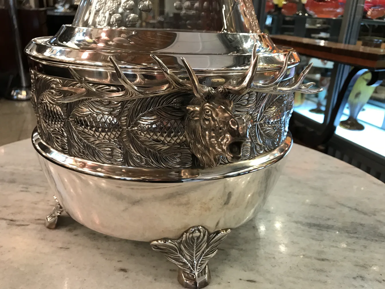 Antique WMF punch bowl featuring deer and leaf reliefs, elegant.