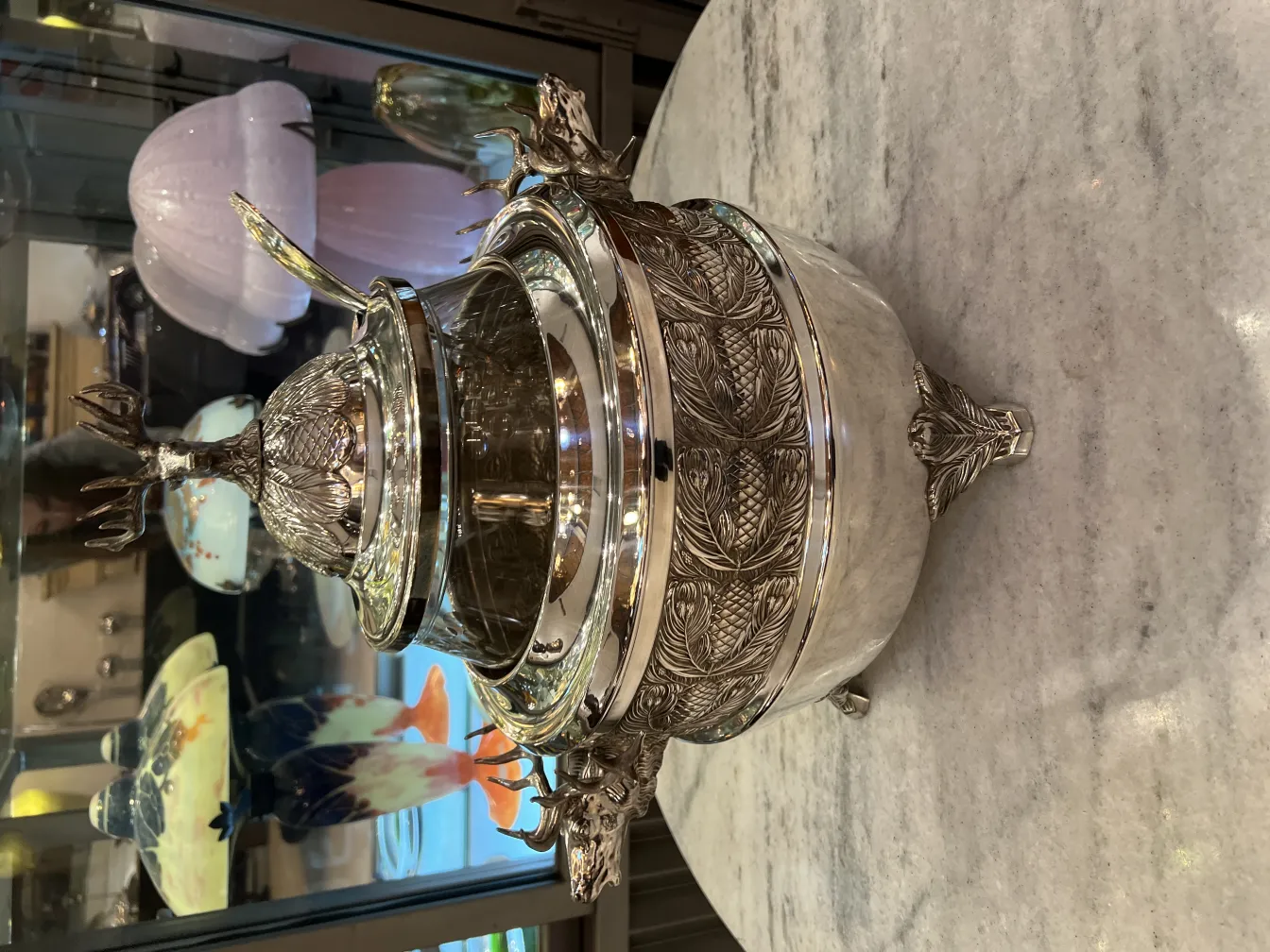 Античная чаша для пунша WMF с декоративной крышкой в форме ананаса, идеальна для празднований, окружена элегантной обстановкой.