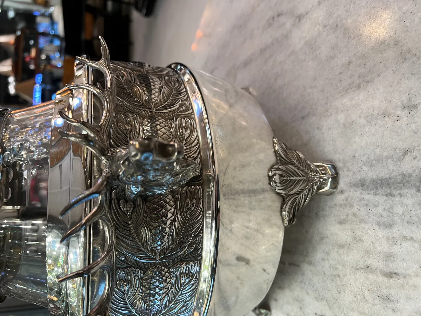 Ponchera WMF antigua con detalles de ciervo y hoja, sobre una mesa