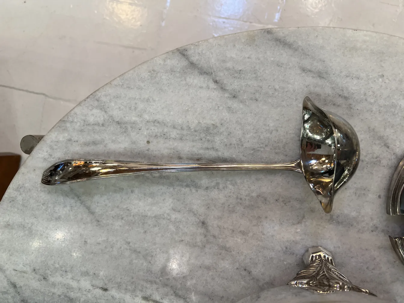 Glänzender Schöpflöffel neben der wauhwf Bowle, auf Marmor