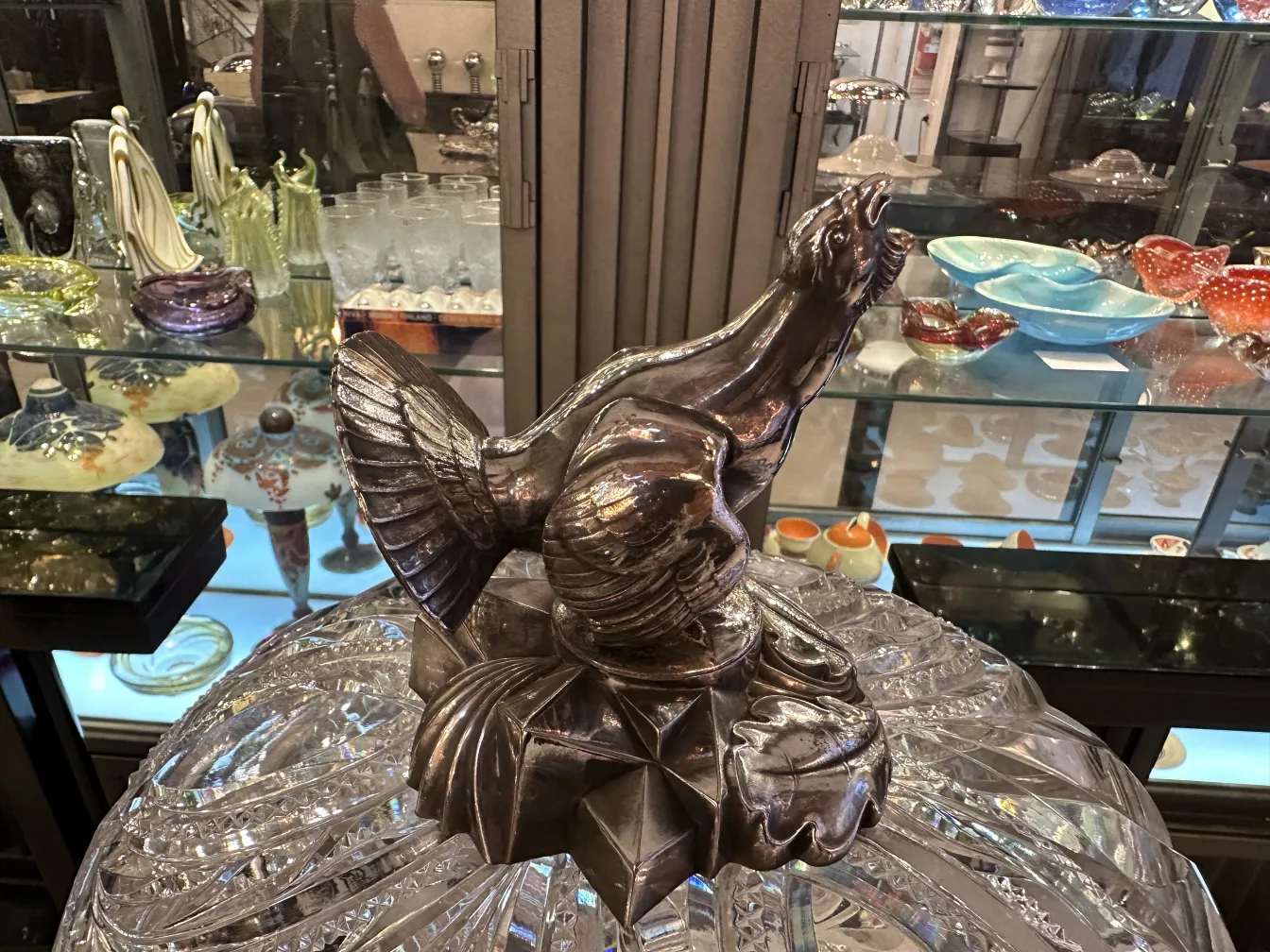 Antique WMF punch bowl with relief design, glassy background.