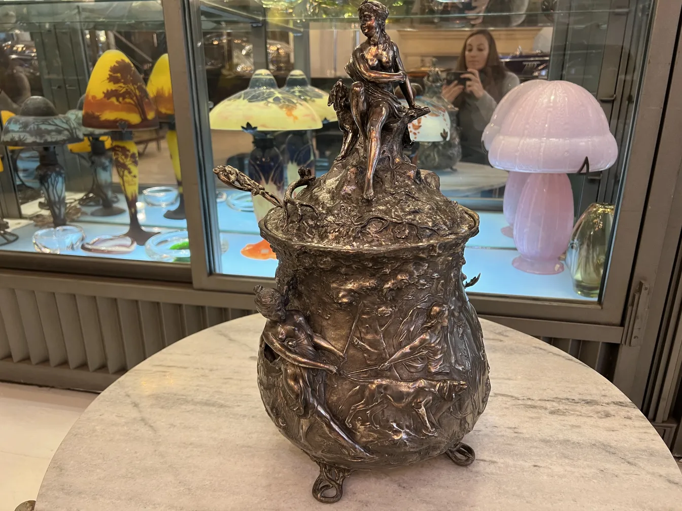 Antica ciotola da punch WMF con dettagli decorativi, mostrata in un ambiente con lampade e oggetti di vetro.