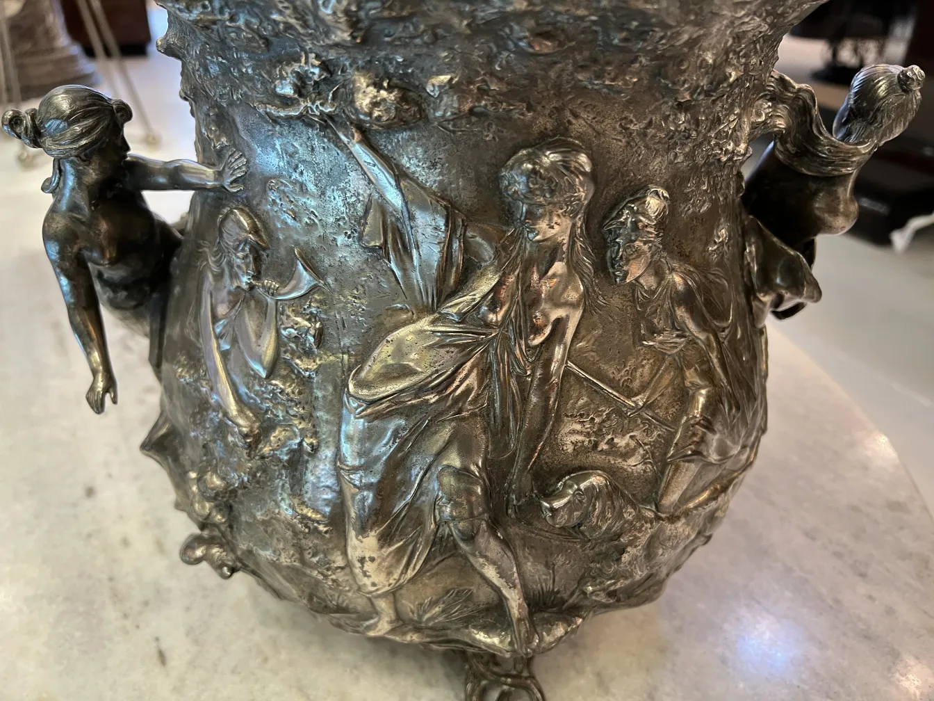 Wide WMF punch bowl decorated with relief figures, elegant ambiance.