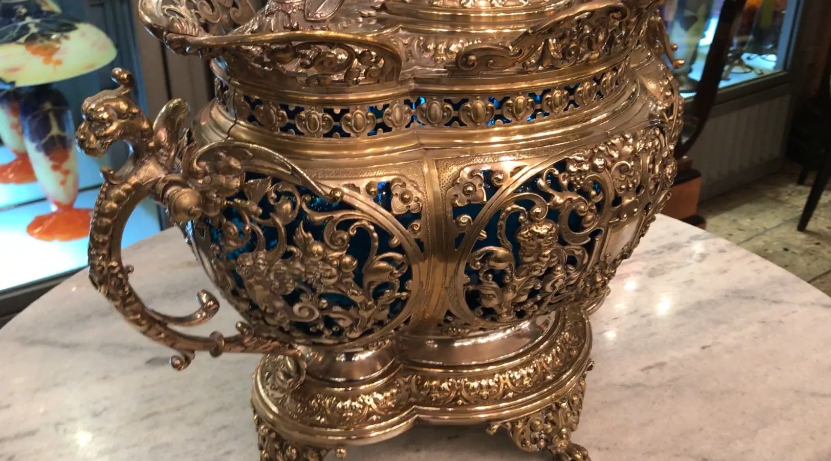 Poncheira antiga wmz com gravações elegantes e detalhes ornamentais, exibida sobre mármore