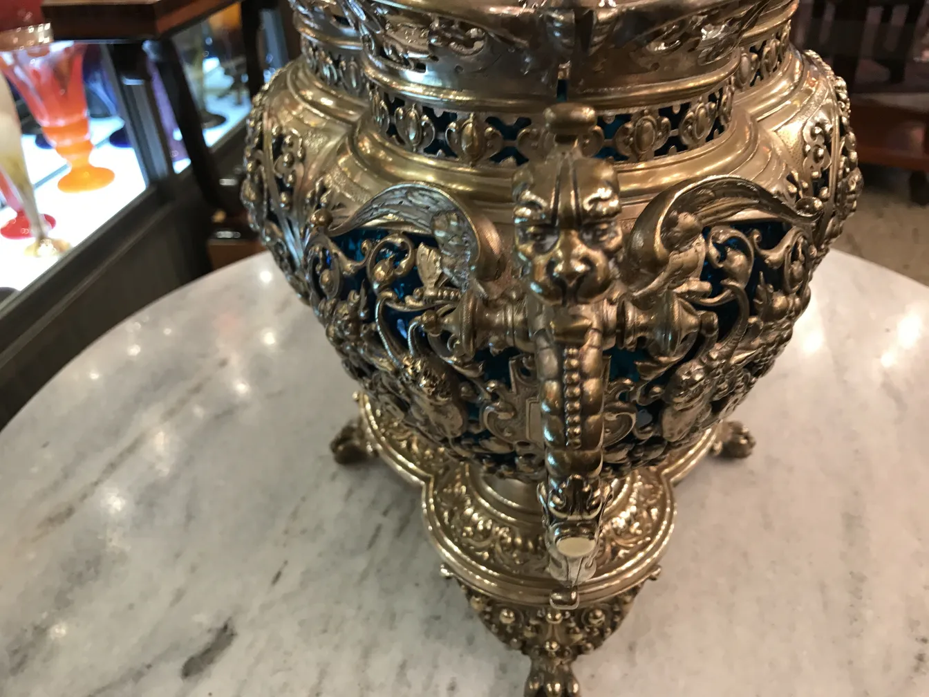 Antique WMF punch bowl with intricate relief details and a shiny finish in an antique setting.