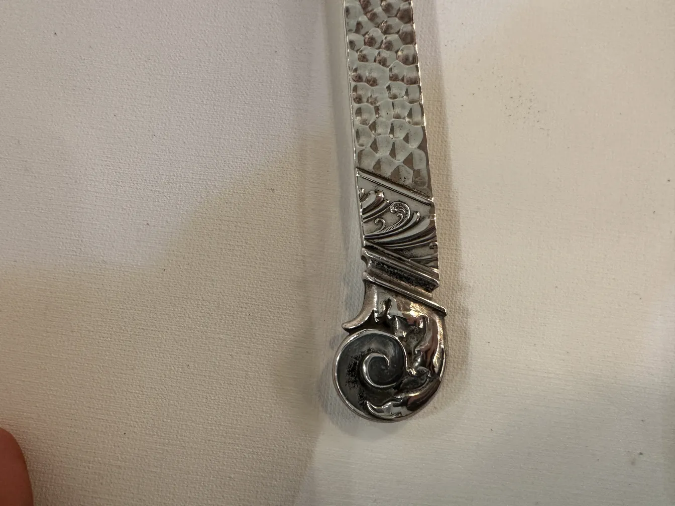 Antica ciotola da punch WMF con decorazioni sottili sul manico, sfondo bianco.