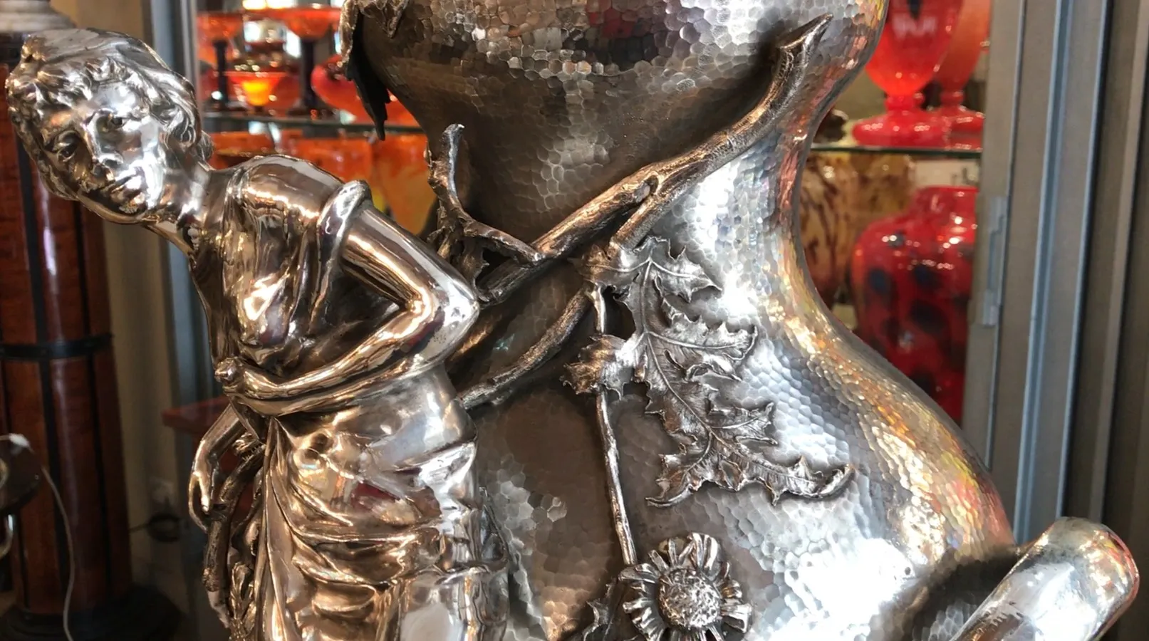 Antique Orivit vase featuring a female figure and floral decorations in a vintage setting.