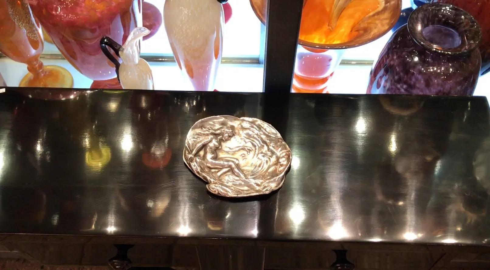 vassoi per carte antichi WMF su una superficie lucida, con oggetti decorativi sullo sfondo