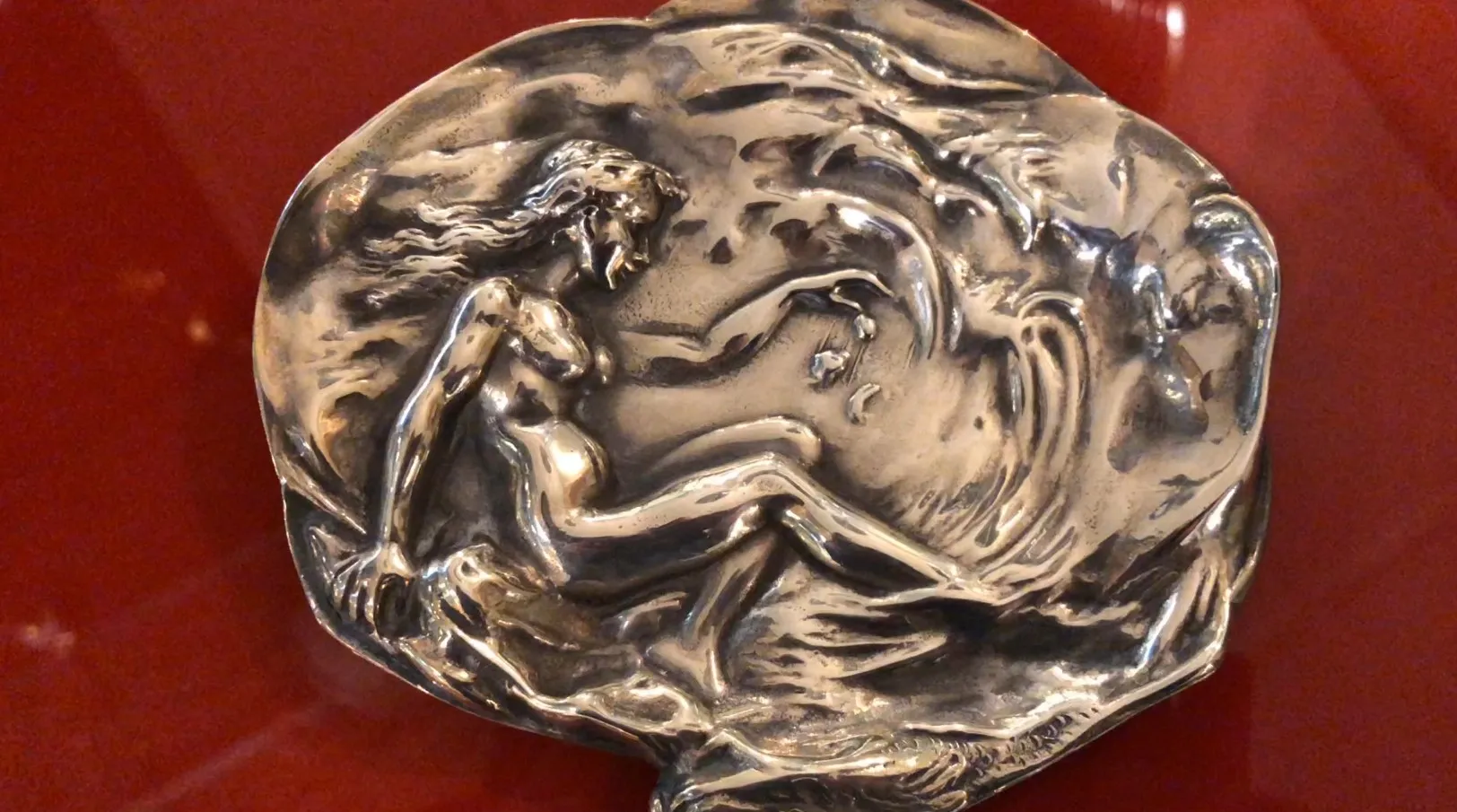 antique WMF card tray with relief figure on red background