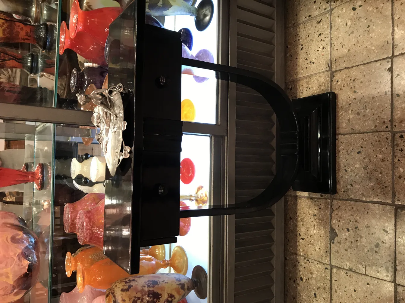 Античный лоток для карточек WMF на фоне декора с яркими цветами.