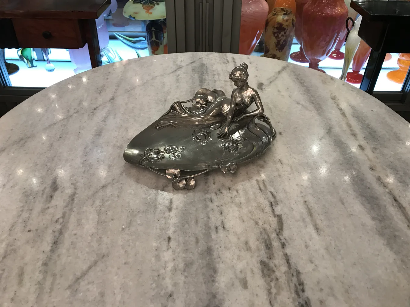 古董WMF卡片托盘，上面有装饰性人物，周围环境优雅。