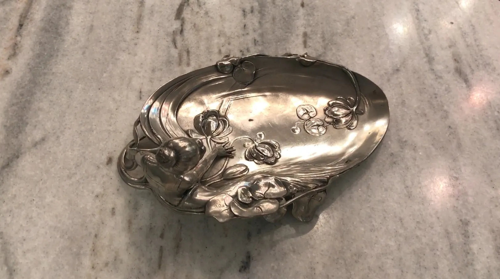 antique WMF card tray with floral design and figure, decorative and functional.