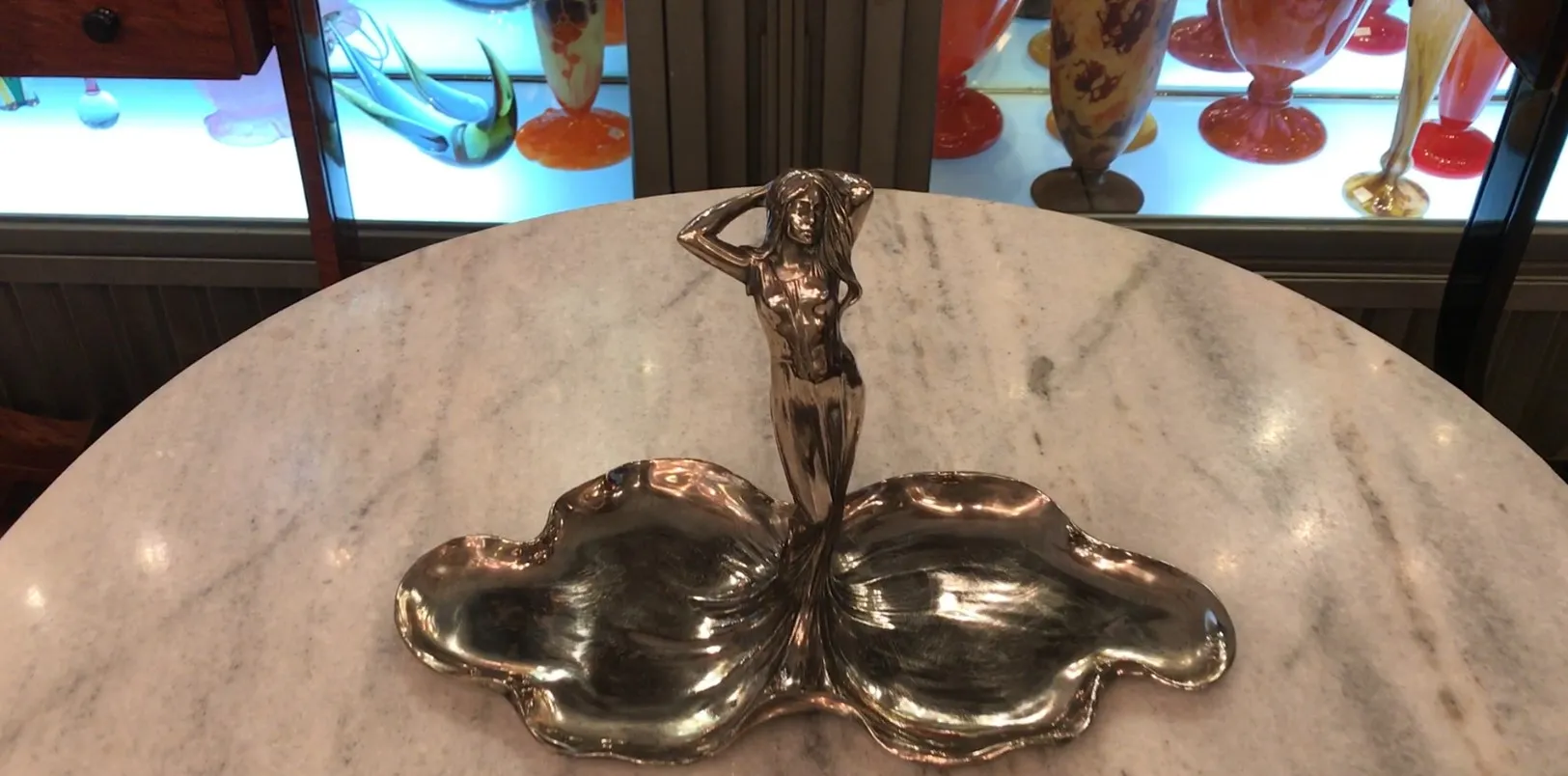 Antikes Kartenfach WMF mit dekorativer Figur und sanften Kurven in einer gemütlichen Umgebung.