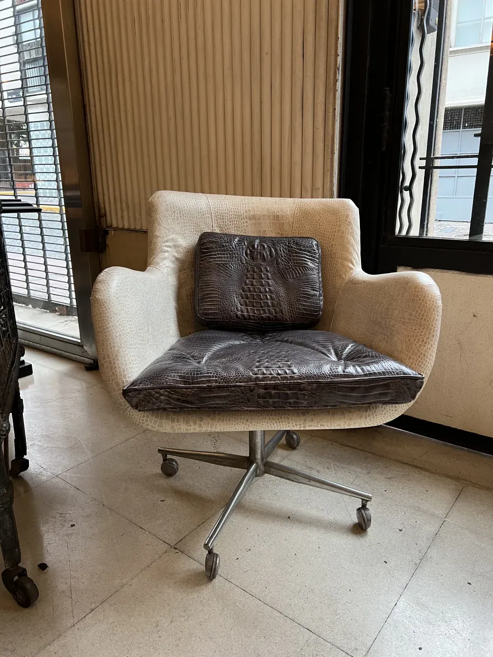 Antique armchair with ergonomic design and decorative cushion in an elegant setting.