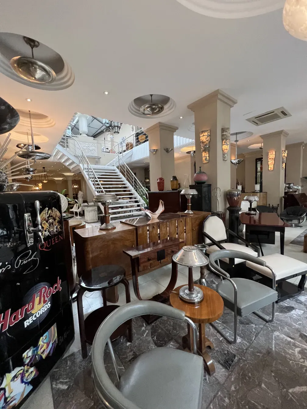 An antique comfortable armchair in an elegant setting with dim lights and wooden tables.