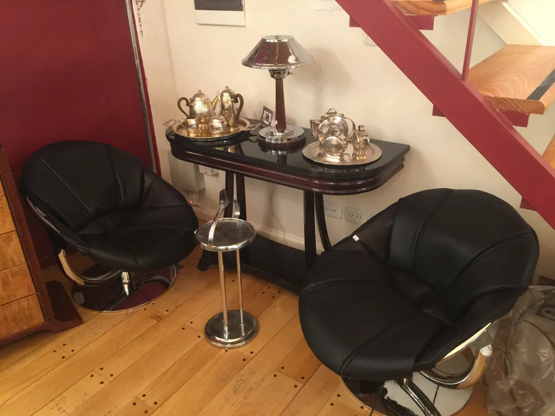 deux fauteuils noirs dans un cadre accueillant avec une table ancienne