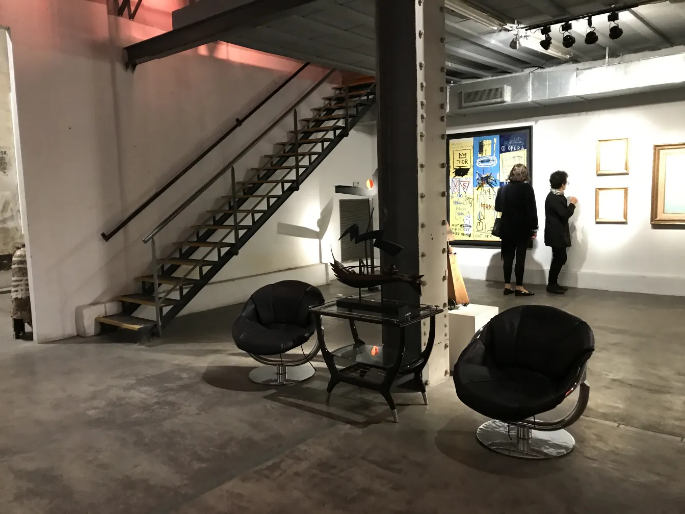 Dos sillones antiguos con detalles modernos en una galería de arte