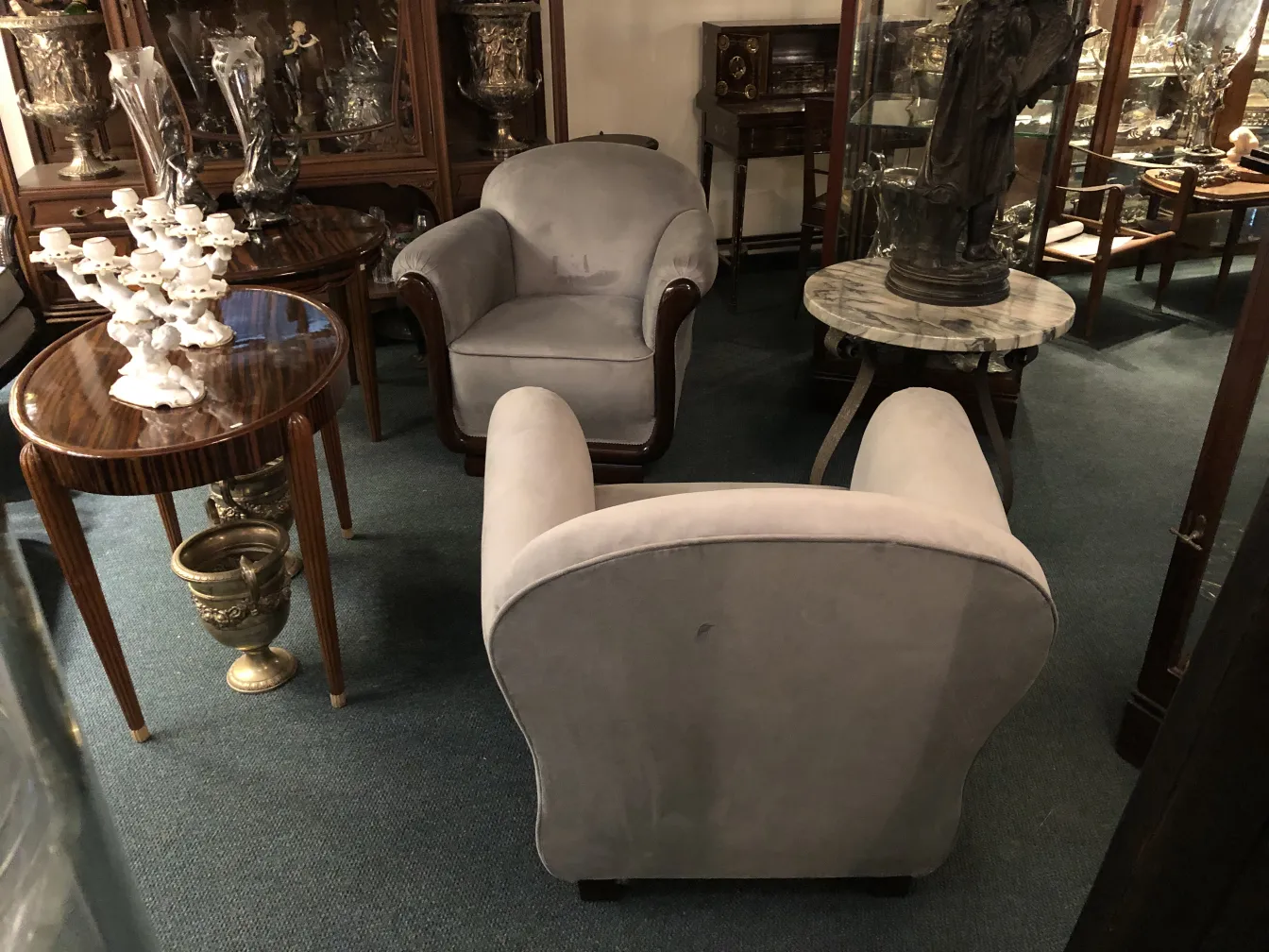 Duas poltronas antiquas em um ambiente elegante.