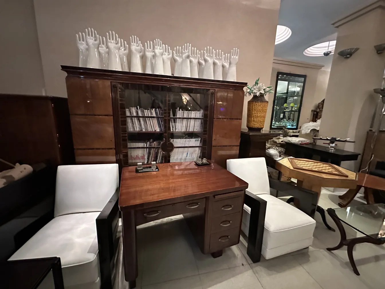 Deux fauteuils anciens blancs à côté d'un bureau et de décorations