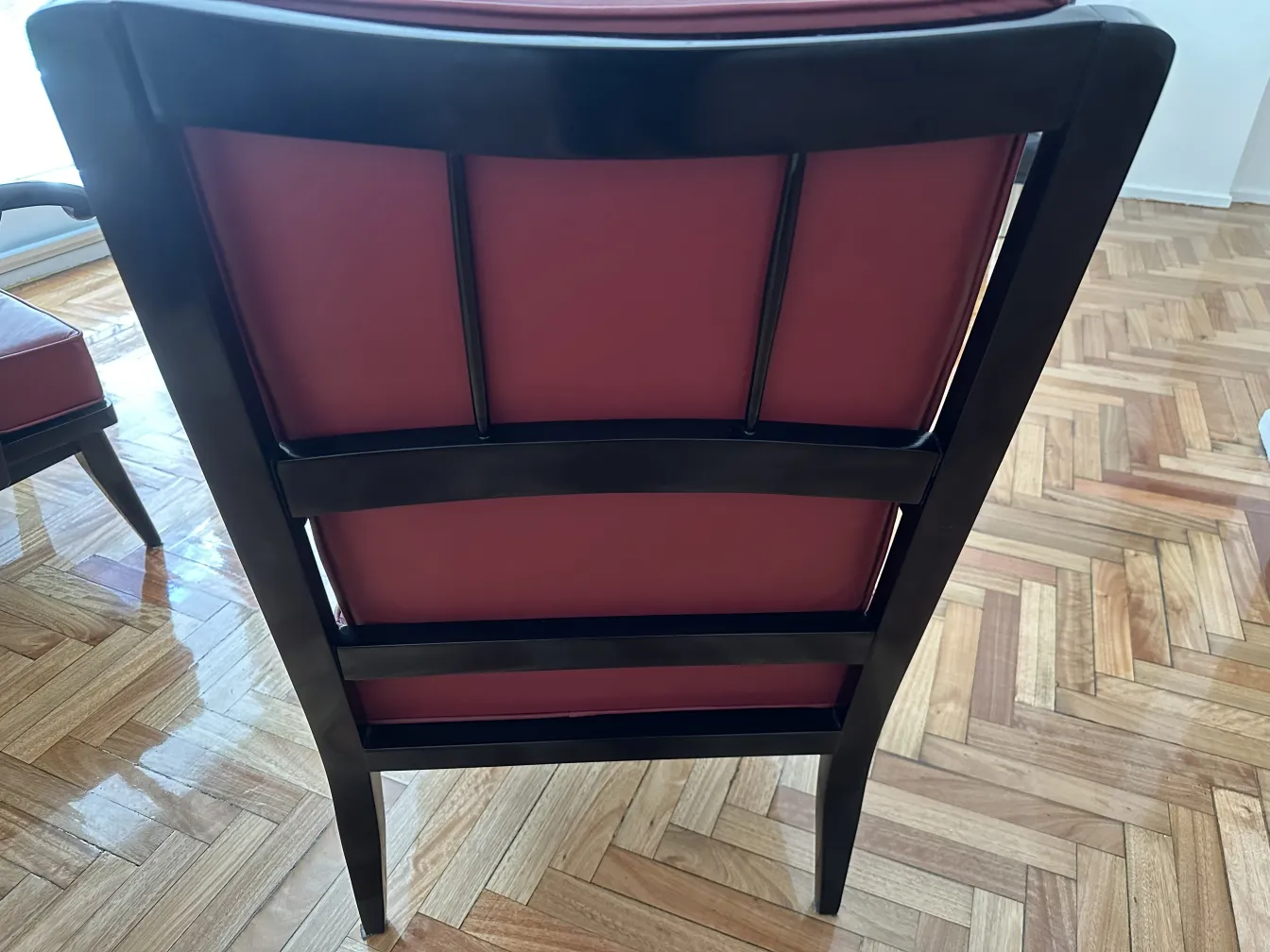 Rear view of two antique armchairs in a cozy setting.