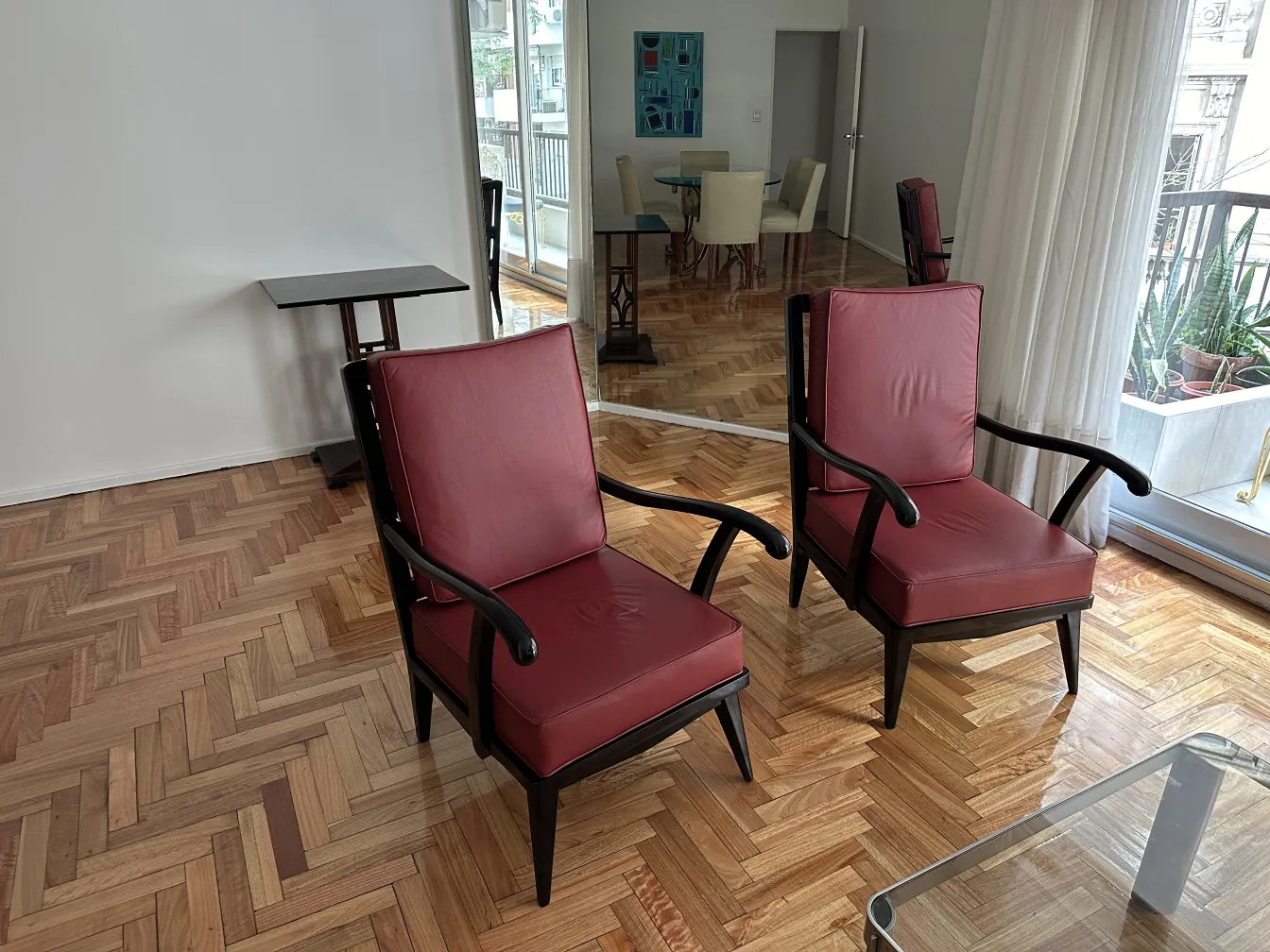 zwei antike rote Armlehnstühle in einem eleganten Umfeld