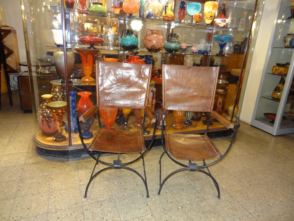 كرسيان عتيقان في بيئة تقليدية مع مزهريات ملونة